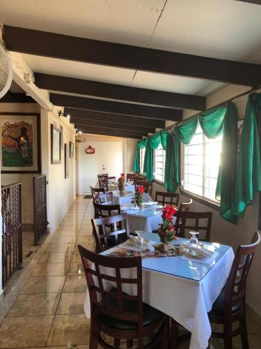 AibonitoTio Pepe’s Guest House的用餐室配有桌椅和绿色窗帘