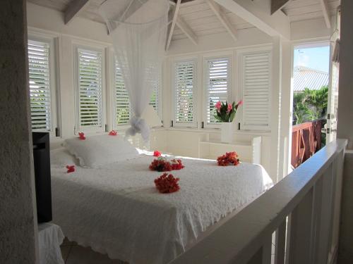 基督教堂市Inchcape Seaside Villas的卧室配有白色的床铺,上面有红色的鲜花