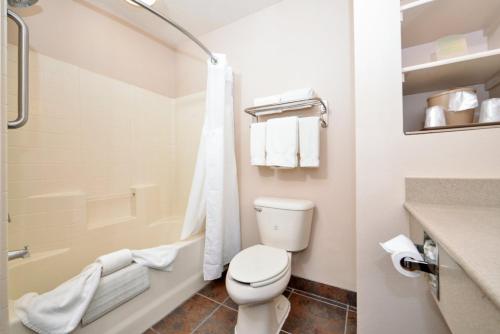 金曼郝丽德皇家快捷酒店的白色的浴室设有卫生间和浴缸。