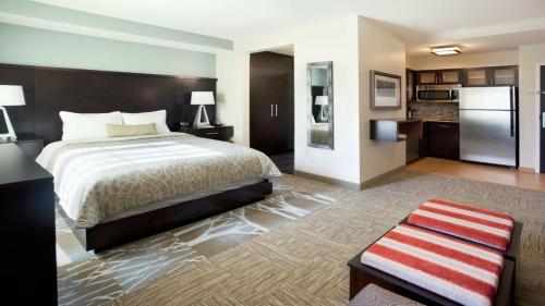 约翰逊城Staybridge Suites - Johnson City, an IHG Hotel的配有床和冰箱的酒店客房
