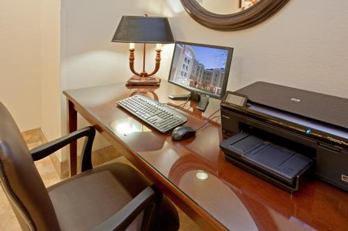 兀兰休斯顿伍德兰烛木套房酒店的一张桌子,上面有一台电脑和一台笔记本电脑