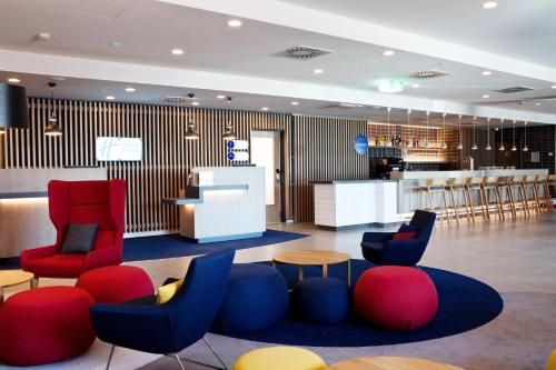 灵斯海姆Holiday Inn Express - Ringsheim, an IHG Hotel的大堂设有红色和蓝色的椅子,酒吧