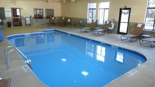 洛根霍金希尔斯 - 洛根智选假日酒店的一个带桌椅的房间的大型游泳池