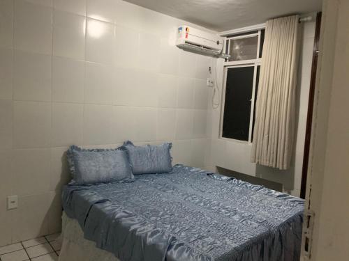 圣路易斯Apto mobiliado no Jardim Renascenca的一间卧室配有一张带蓝色床单的床和一扇窗户。
