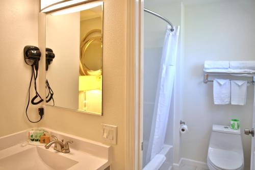 新奥尔良市Travelodge by Wyndham Crescent City的一间带水槽、镜子和卫生间的浴室