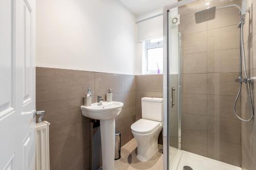 达特福德Dartford, Kent - Modern 2Bd 2Bath En-Suite Bungalow M25 Bluewater的浴室配有卫生间、盥洗盆和淋浴。
