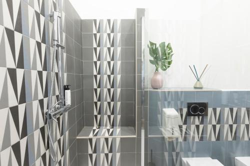 佛罗伦萨民间博物馆50米塞利酒店的浴室铺有灰色和白色瓷砖,配有淋浴。