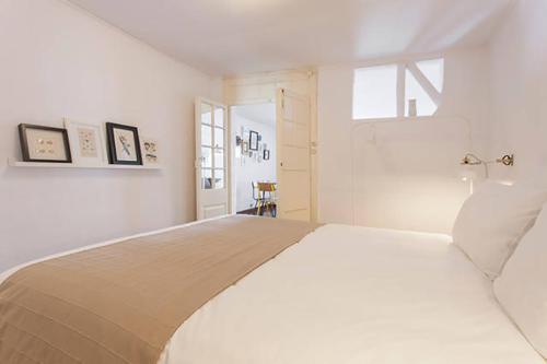 里斯本巴洛奥尔多橡树谷公寓的卧室配有一张大白色床和窗户