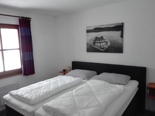 弗兰克瑙Ferienhaus Rudi的一间卧室配有一张带白色床单的床和一扇窗户。