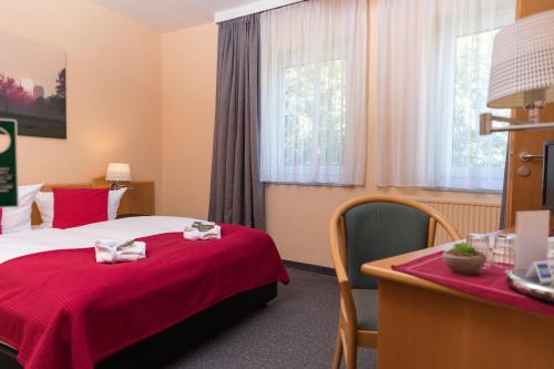 居斯特罗艾姆迪安帕克酒店的酒店客房,配有一张带红色毯子的床
