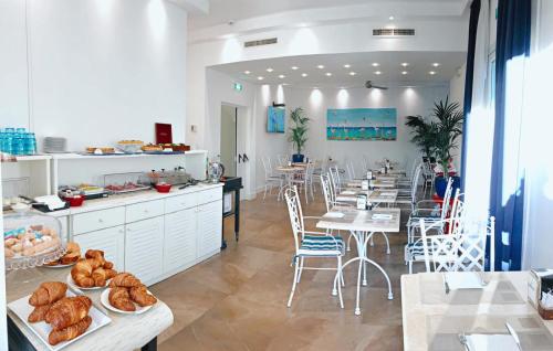 卡利亚里诺迪鲁斯酒店的一间带桌椅的餐厅和一间面包店