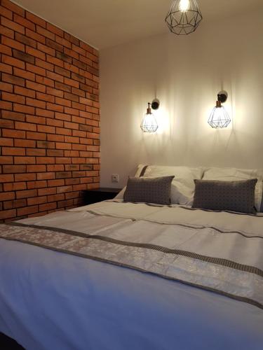 格利维采MISVEST Maria IV Arena Gliwice的一间卧室设有一张带砖墙的大床