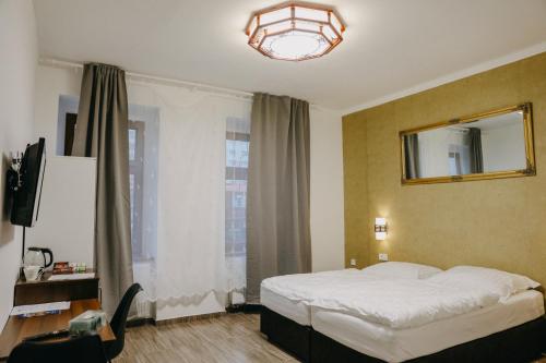 特普利采OASIS Teplice的一间卧室配有一张床、镜子和窗户
