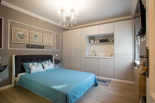 布加勒斯特62 Steps to Petit Bonheur的一间带蓝色床的卧室和一间厨房