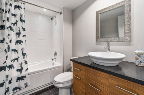 博普雷INITIAL - L'OURS - Mont-Sainte-Anne的浴室配有水槽、卫生间和浴帘