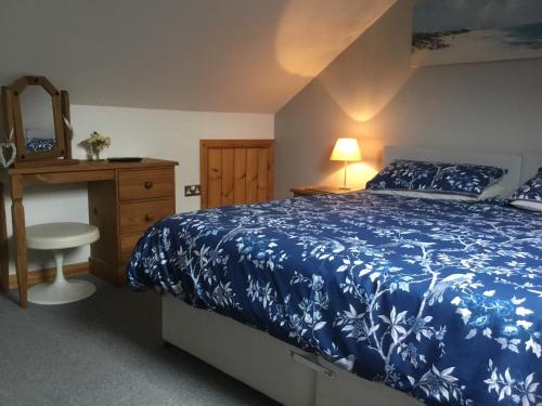 兰贝里斯泰德林博瑟农场酒店的一间卧室配有蓝色的床、梳妆台和镜子