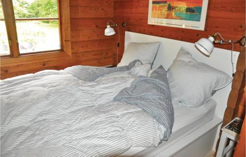 奥特鲁普2 Bedroom Cozy Home In Otterup的一张带条纹床单和枕头的床