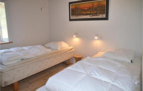 StavsøCozy Apartment In Nrre Nebel With Wifi的卧室配有两张床,墙上挂着一幅画