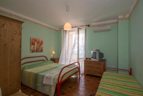 罗迪-加尔加尼科Agriturismo Nardini的一间卧室设有两张床、一台电视和一扇窗户。