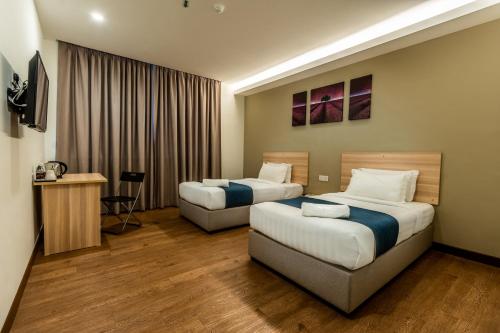 雪邦1 Orange Hotel KLIA & KLIA2的酒店客房设有两张床和电视。