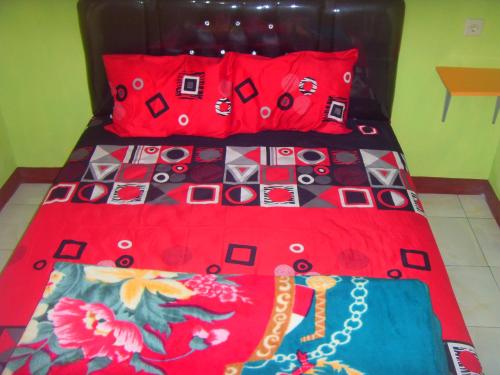 布罗莫卡优布罗莫民宿的一张带红色棉被和红色枕头的床