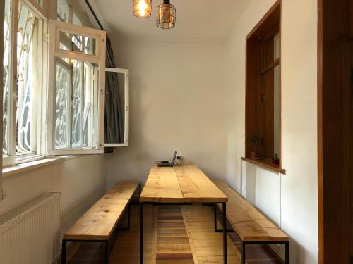 第比利斯Vac Hostel的配有2扇窗户的客房内的木凳