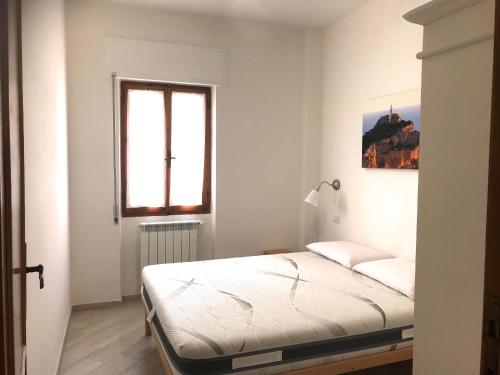 阿尔盖罗Home Feeling Mascagni - Bilocale的白色的卧室设有床和窗户