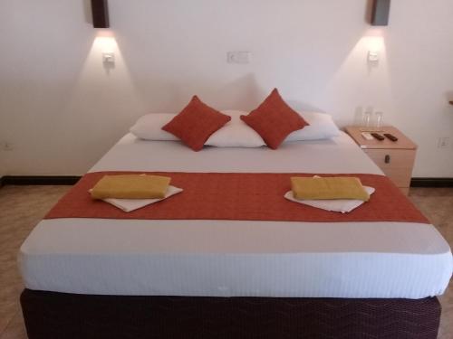 波隆纳鲁沃Kithmi Resort的一间卧室配有一张大床和两个枕头