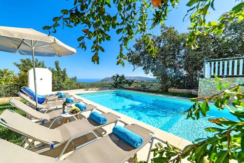 GeorgioupoliGrand View Villa Private Heated Pool的一个带躺椅和桌子的游泳池以及一个游泳池