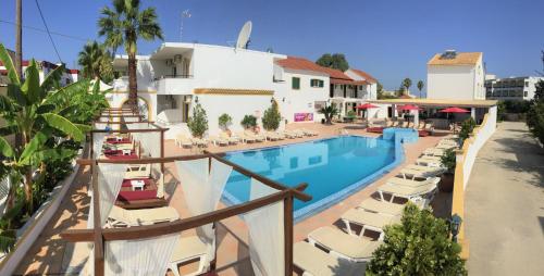 卡沃斯Oasis Beach Club的一个带躺椅的游泳池和一间酒店