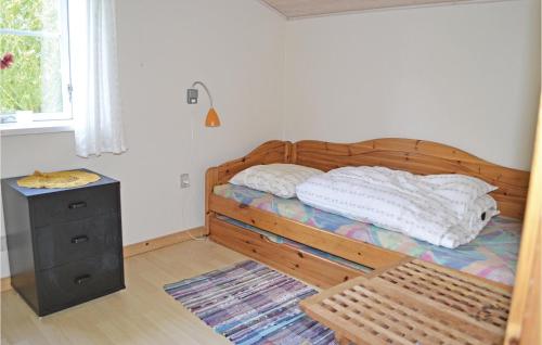 Mandø ByBeautiful Home In Ribe With Wifi的一间卧室配有一张木床、床头柜和窗户