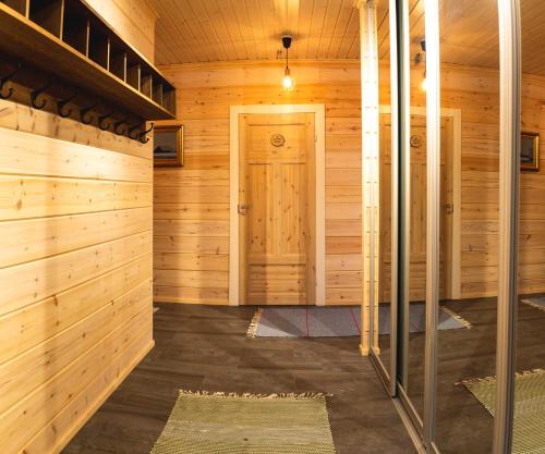 萨利色尔卡Arctic Sky Lapland的一间设有木墙和门的桑拿浴室