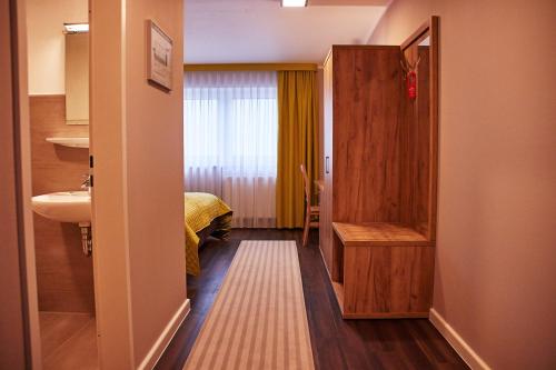 贝格海姆Joos Hotel的客房设有带一张床和盥洗盆的浴室