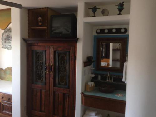 圣地亚哥秘密花园酒店的一间带水槽的浴室和一个带电视机的橱柜