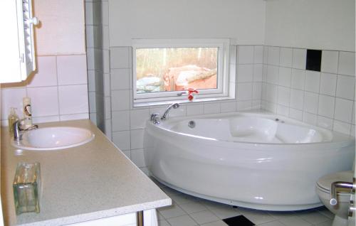 斯泰厄Amazing Home In Stege With 3 Bedrooms, Sauna And Wifi的白色的浴室设有浴缸和水槽。