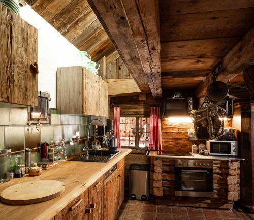 RamsauRomantische Hütte的厨房配有木制橱柜和带水槽的台面