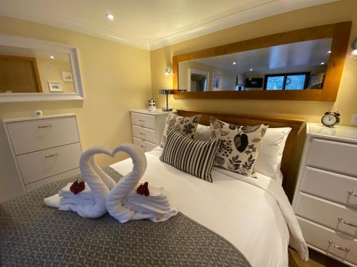 达农The Wee Ludging Cottage, Rashfield, by Dunoon的两只天鹅用毛巾制成,坐在床上