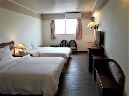 新竹Hsinchu Shih business hall的酒店客房设有两张床和电视。