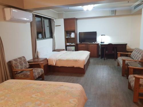 新竹Hsinchu Shih business hall的酒店客房设有两张床和一台平面电视。