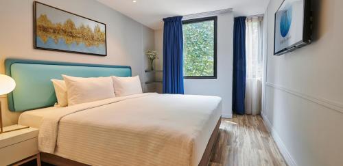 吉隆坡J-Hotel by Dorsett的一间卧室设有一张大床和一个窗户。