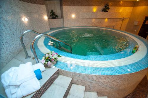 阿斯塔纳阿斯塔纳卡佐尔酒店 的一个带毛巾的酒店客房内的大型游泳池