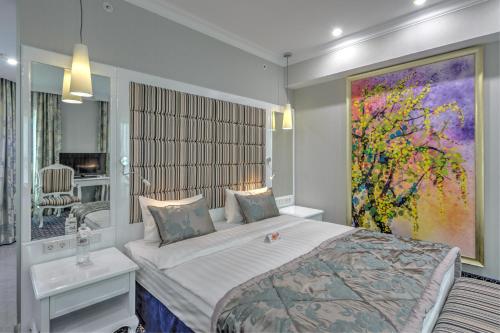 阿斯塔纳阿斯塔纳卡佐尔酒店 的卧室配有一张床,墙上挂有绘画作品