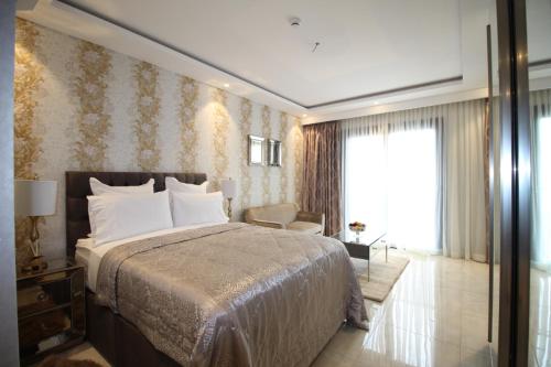 阿克拉APARTMENTS GH - Accra - Airport Residential Area - Mirage Residence的一间卧室设有一张大床和一个大窗户