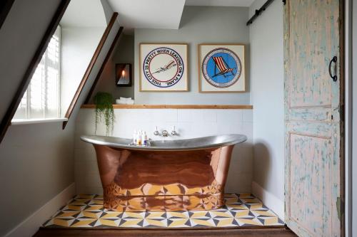 布莱顿霍夫布莱顿艺术家驻地公寓的铺有瓷砖地板,设有带大浴缸的浴室