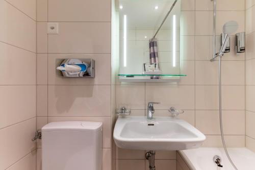 日内瓦Hôtel Les Nations的一间带水槽、卫生间和镜子的浴室
