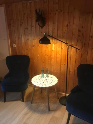 奥贝里德Stollenbacher Hütte auf 1092m的一张桌子,房间配有两把椅子和一盏灯