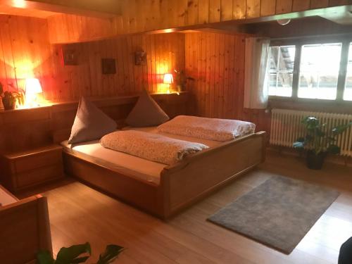 奥贝里德Stollenbacher Hütte auf 1092m的卧室配有一张床铺,位于带木墙的房间内