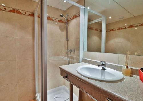 尼斯Hôtel restaurant Oasis的一间带水槽和淋浴的浴室