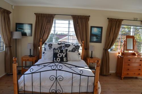 开普敦Whale Tale的一间卧室配有一张床、一个梳妆台和一扇窗户。