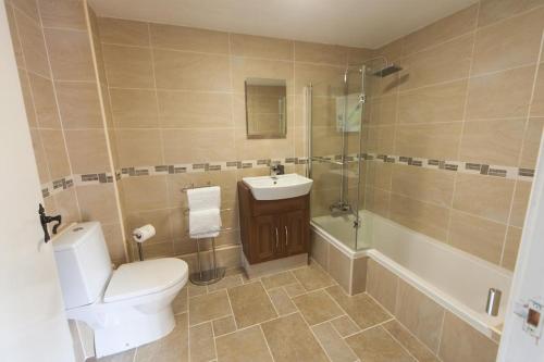 格兰瑟姆伍德豪斯阿姆斯宾馆的浴室配有卫生间、盥洗盆和淋浴。